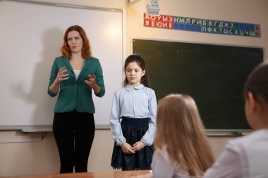 Yaşlı öğretmen öğrenci matematik dersine soran kara tahta yakınındaki gülümseyen
