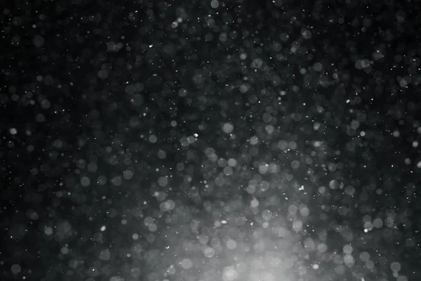 Close up textura de fundo de flocos de neve durante uma queda de neve em um fundo preto — Fotografia de Stock