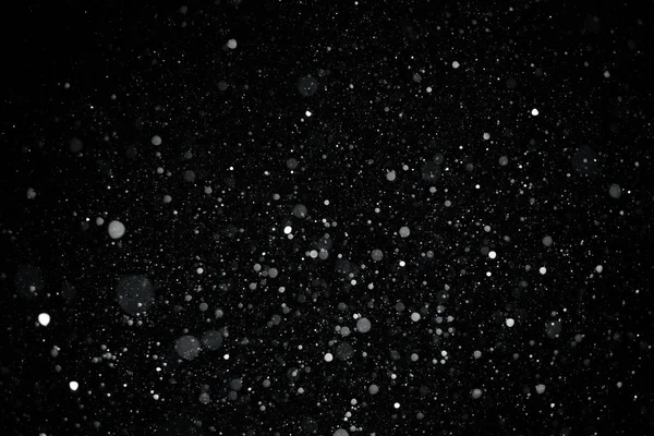 Closeup background texture of snowflakes during a snowfall on a black background — Stock Photo, Image