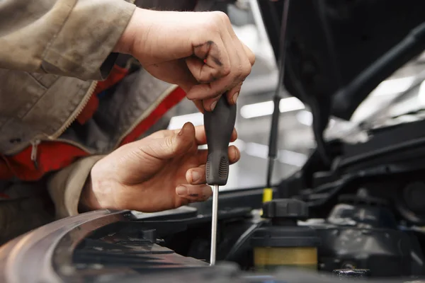 Mecánico con faro de coche nuevo en un taller —  Fotos de Stock