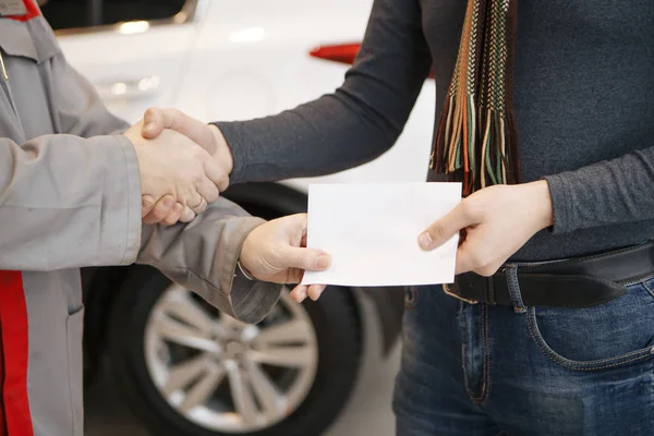 Good deal. Close-up shoot of the hands shaking in front of the car