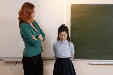 öğretmen ve öğrenci laptop, ekran işaret eden kız