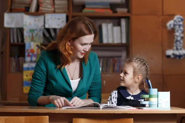 De vuelta a la escuela. El niño está aprendiendo a escribir. Mujer adulta enseña a niño el alfabeto . — Foto de Stock