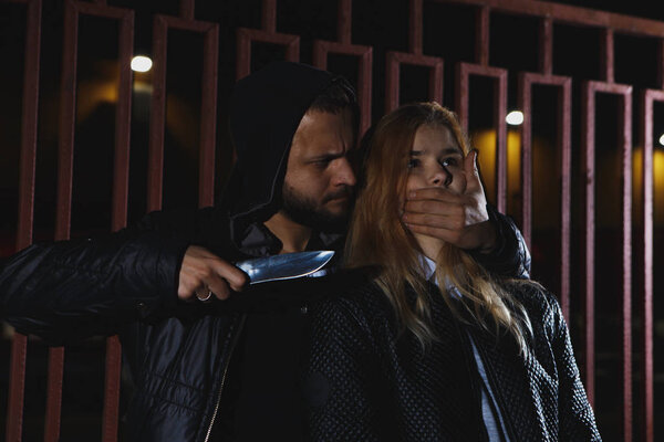 GIRL SELF DEFENSE A young woman defends herself against a male attacker in an alley by elbowing him in the jaw. Refuse to be a victim.