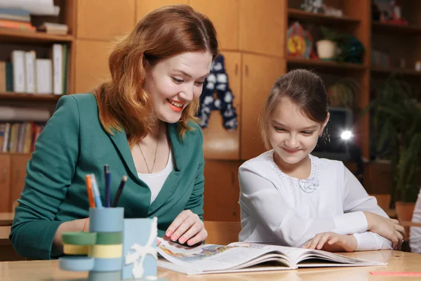 Madre ayudando al niño después de la escuela. preescolar haciendo la tarea con la ayuda del tutor. concepto de enseñanza en casa . — Foto de Stock