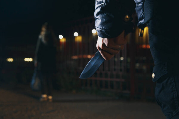 Концепции ограбления грабитель направил свой острый нож на женщину, чтобы ограбить ее ценные вещи в сумке
