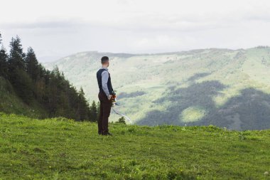 Düğün. Damat bir gömlek ve yelek bir ilik ile bahçede olduğunu