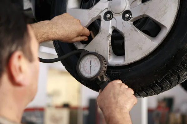 Mecánico cambio de rueda de coche en taller de reparación de automóviles —  Fotos de Stock