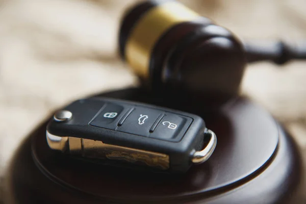 Close-up de Gavel e chave do carro no bloco de som contra fundo cinza — Fotografia de Stock