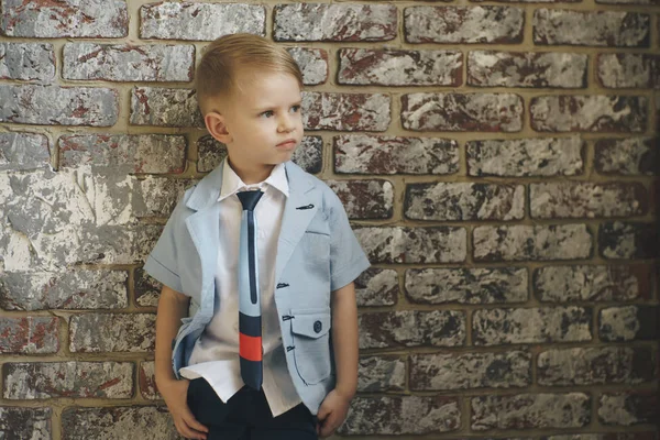 Cute stylish boy near light brick wall — Stock Photo, Image