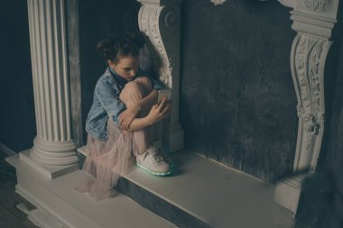 Bir cep telefonu ile koyu arka planda yatak odasında yatağın üzerinde oturan ağıt tutmak tek üzücü teen