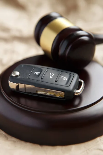 Close-up de Gavel e chave do carro no bloco de som contra fundo cinza — Fotografia de Stock