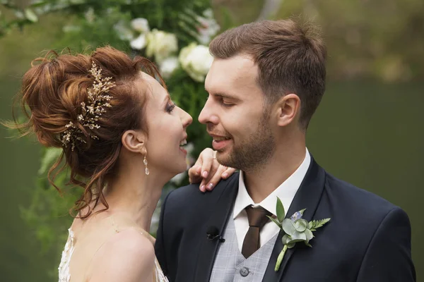 Novia y novio en un parque kissing.couple recién casados novia y novio en una boda en la naturaleza verde bosque están besando foto portrait.Wedding Pareja —  Fotos de Stock