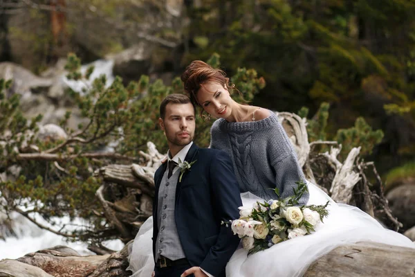 La novia y el novio en el fondo de un arroyo de montaña —  Fotos de Stock