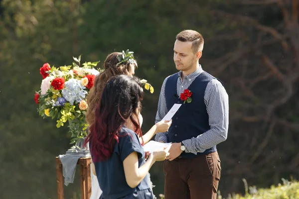 Retrato vintage de una joven pareja hipster posando en suite de bodas y vestido al atardecer en el bosque — Foto de Stock