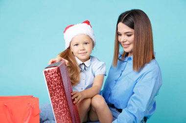 Yeni yıl konsepti. Anne ve çocuk hediyelerle birlikte oturuyor..