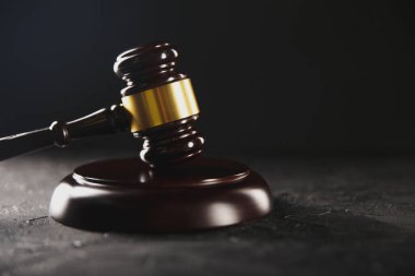 Wooden judje gavel on the dark table isolated.
