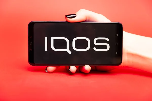 26 08 2019 Tula: Logo Iqos na displeji telefonu na červeném pozadí. — Stock fotografie