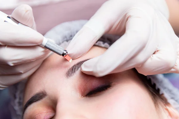 Cosmetic procedures for the treatment of eyebrows. Microblading in the beauty salon. Professional cosmetology. The process of applying the pigment — Stock Photo, Image