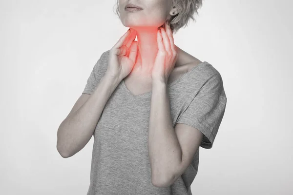 Mujer revisando la glándula tiroides sola. Primer plano de mujer en camiseta blanca tocando cuello con mancha roja. El trastorno tiroideo incluye bocio, hipertiroides, hipotiroides, tumor o cáncer. Asistencia sanitaria. — Foto de Stock