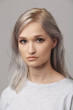 Beyaz stüdyoda poz veren genç bir kadın model..