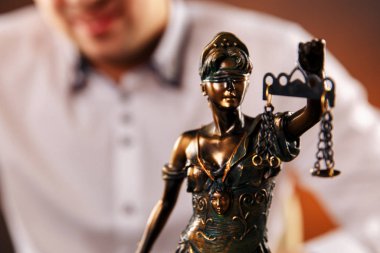 Belgelerle çalışan, kalemle bilgi yazan avukat. Adalet Heykeli