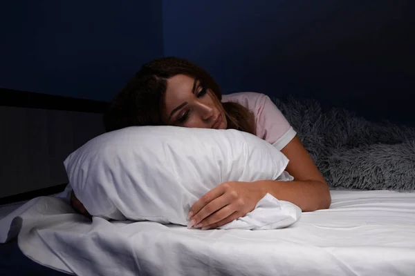 Schlaflosigkeit. schlaflose, traurige junge Frau im Bett. — Stockfoto