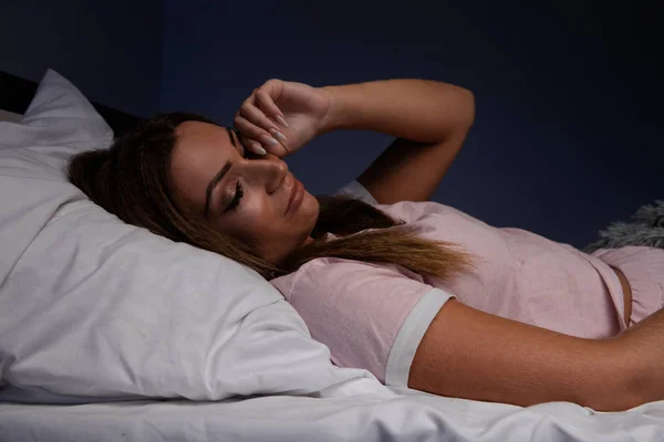 Schlaflosigkeit. schlaflose, traurige junge Frau im Bett. — Stockfoto