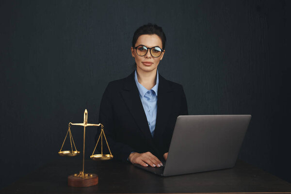 Lawyer office. Statue of Justice with scales and lawyer working on a laptop. Legal law, advice and justice concept