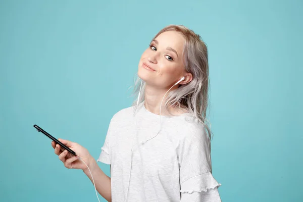 Šťastná žena s bílými sluchátky a telefonem izolované poslech hudby. — Stock fotografie