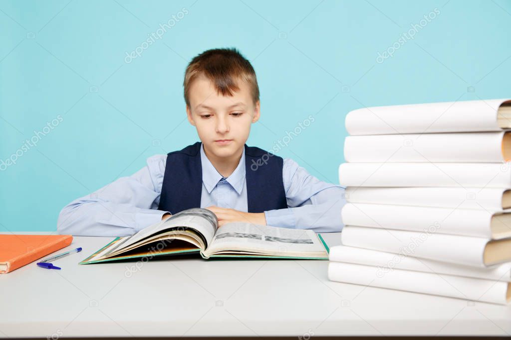 Education at school concept. Boy sitting at the table and studying isolated.
