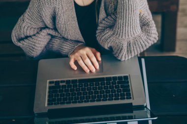 Parkta dizüstü bilgisayarda çalışan mutlu hipster genç kadın