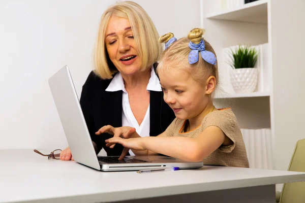 Leraar met klein meisje typen op de laptop in de klas. — Stockfoto