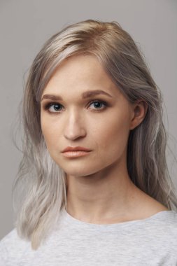 Beyaz stüdyoda poz veren genç bir kadın model..