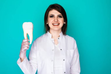 Mavi arka planda tek başına duran dişçi kadının fotoğrafı..