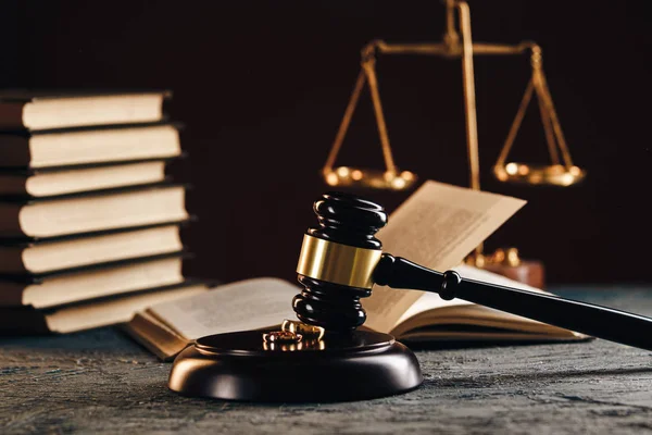 Los anillos de boda en la figura del corazón roto del árbol, el martillo del juez sobre el fondo de madera. Procedimientos de divorcio —  Fotos de Stock