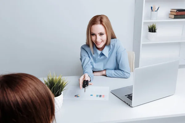 Yong mujer bonita sosteniendo las llaves y dándosela al cliente. Contrato de compra de un coche . — Foto de Stock