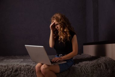 Kötü laptop konsepti. Defterde çalışan genç bir kadın kendini kötü hissediyor..