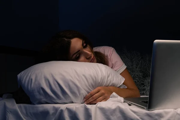 Gestresste Frau im Bett, die am Laptop arbeitet. — Stockfoto