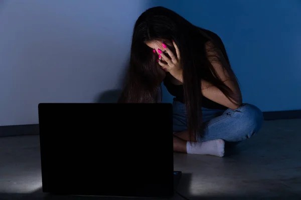 Adolescente triste y femenina con tableta y computadora portátil que sufre acoso cibernético y acoso siendo abusada en línea por acosador o chismoso sintiéndose desesperado y humillado en acoso cibernético . — Foto de Stock