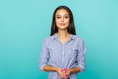 Mavi stüdyoda poz veren güzel bir genç kadın..