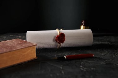 Noter konsepti. Masanın üzerinde balmumu mühür ve kalemle yazılmış bir kitap ve sözleşme..