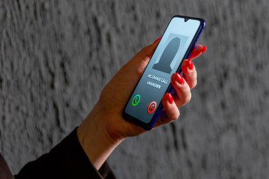 Phone call from unknown number. Scam, fraud or phishing with smartphone concept. Prank caller, scammer or stranger. Woman answering to incoming call. Hoax person with fake identity