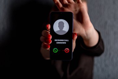 Phone call from unknown number. Scam, fraud or phishing with smartphone concept. Prank caller, scammer or stranger. Woman answering to incoming call. Hoax person with fake identity