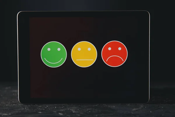 Tablet comentários conceito. Sorrisos diferentes no gadget . — Fotografia de Stock
