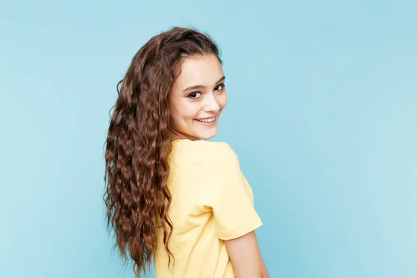 Beauty Casual Fasion Portrait. lockiges Haar nette Frau posiert isoliert über dem blauen Hintergrund. — Stockfoto