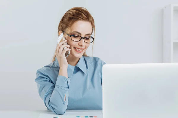 Όμορφη ξανθιά κοπέλα γραφείο μιλώντας τηλεφωνικώς στο χώρο εργασίας της. — Φωτογραφία Αρχείου