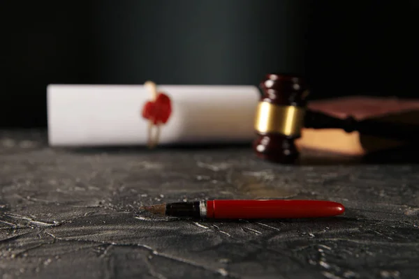 Notaire et concept de droit. Timbre avec livre et stylo sur la table. Gavel en bois derrière . — Photo