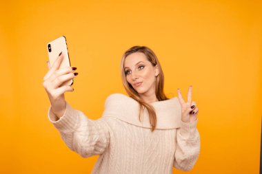 Parlak makyajlı güzel bir kadın stüdyoda fotoğraf çekiyor..