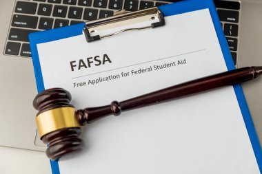 Öğrenci yardımı ve dizüstü bilgisayarlı ahşap tokmağın olduğu belge. Fafsa.
